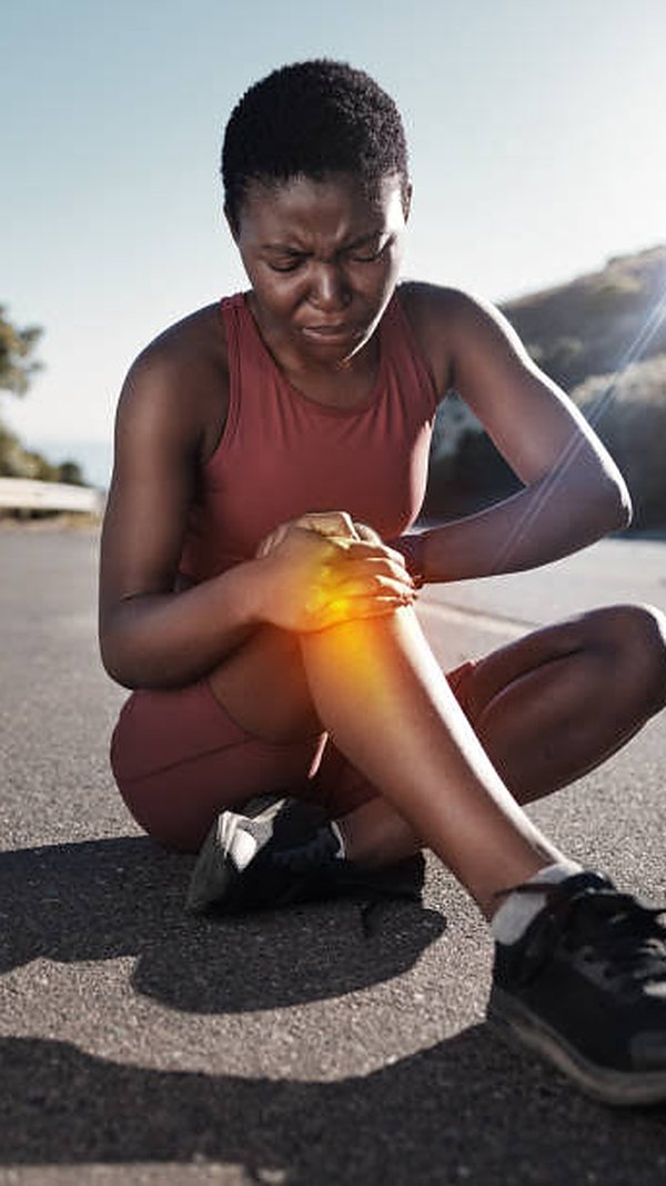 Woman holding her knee in pain, representing knee arthritis