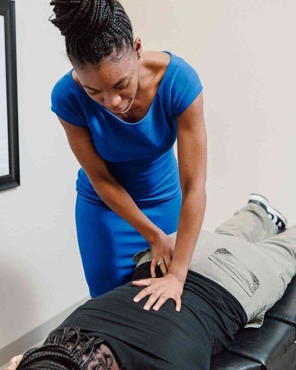 Physiotherapist treating a woman lying on a treatment table, representing posture correction