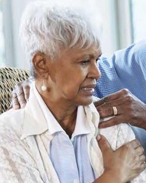 Older woman holding her shoulder in pain, representing shoulder and hip pain care